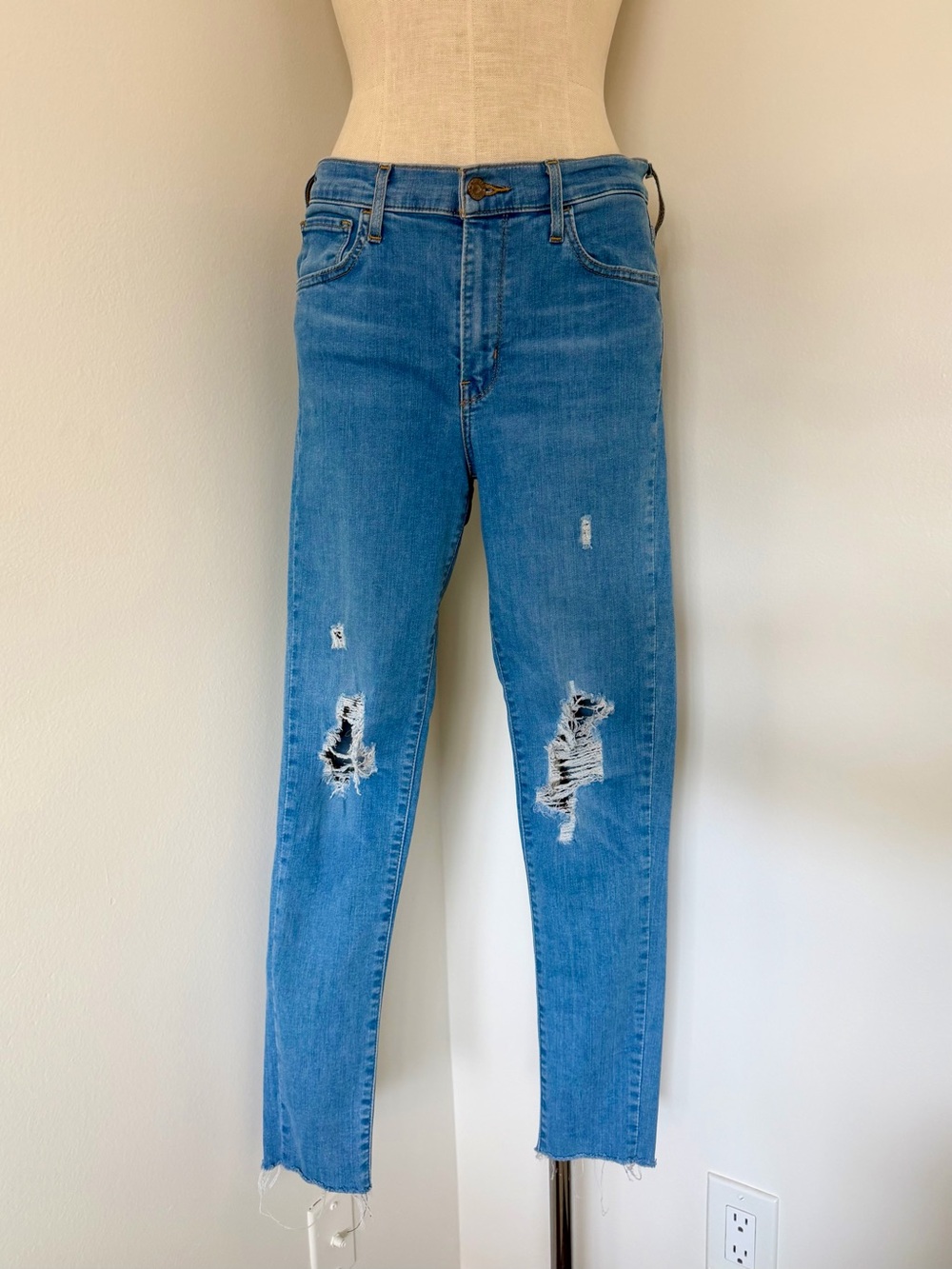 Levi's 720 High-Rise Super Skinny jeans featuring knee rips and a raw hem